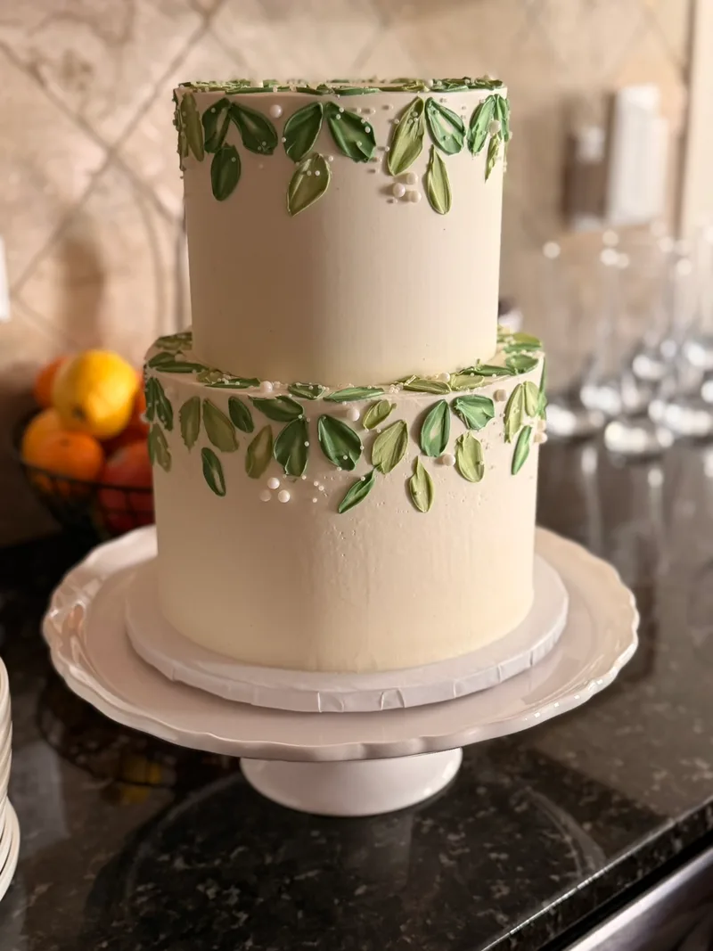 6" and 8" cake with smooth frosting, green leafs and pearls.
